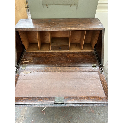 175 - A 1930s oak bureau with two drawers, fall front and baluster supports