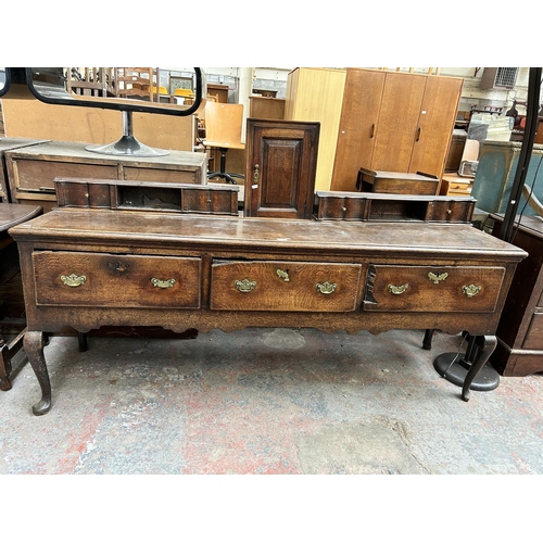 182 - A Georgian oak dresser base with three drawers and cabriole supports
