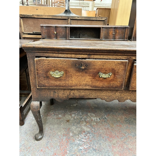 182 - A Georgian oak dresser base with three drawers and cabriole supports