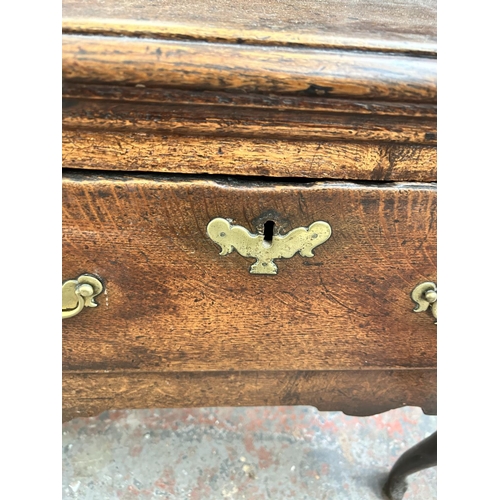 182 - A Georgian oak dresser base with three drawers and cabriole supports