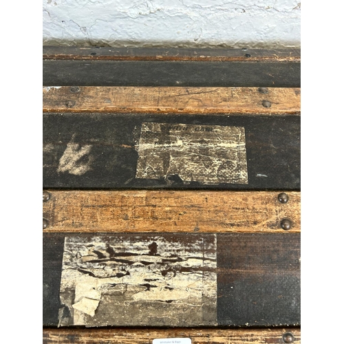 187 - An early 20th century wooden banded and canvas dome top travel trunk