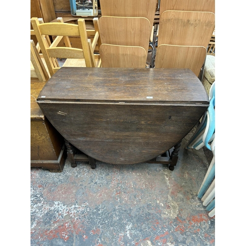 190 - An early 20th century oak drop leaf gate leg dining table on barley twist supports