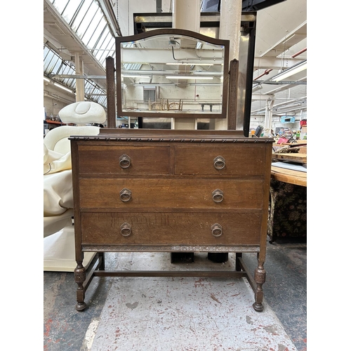 196 - An early 20th century oak dressing chest with two short drawers, two long drawers and upper bevelled... 