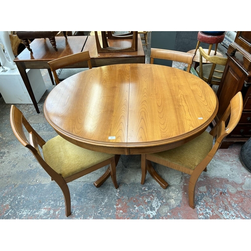 200 - A teak oval extending dining table and four matching dining chairs