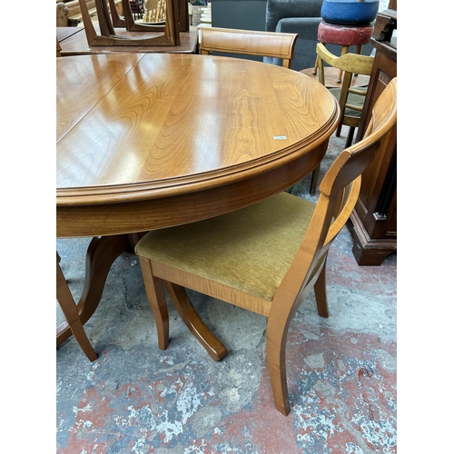 200 - A teak oval extending dining table and four matching dining chairs