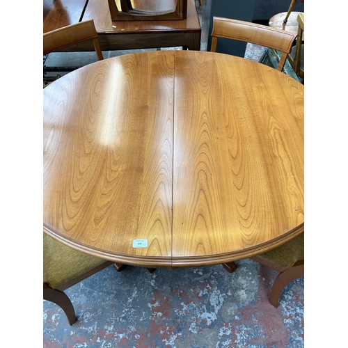 200 - A teak oval extending dining table and four matching dining chairs