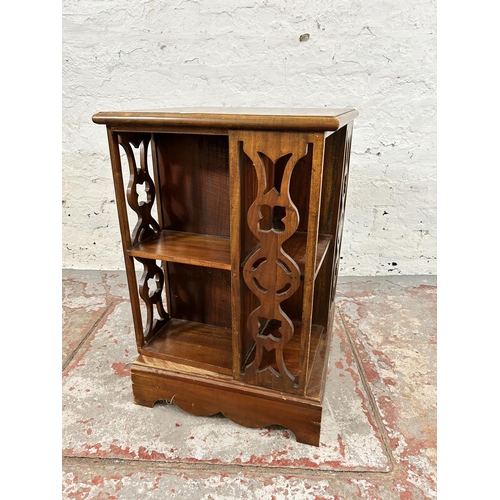 204 - An Edwardian style hardwood revolving bookcase with fretwork panels