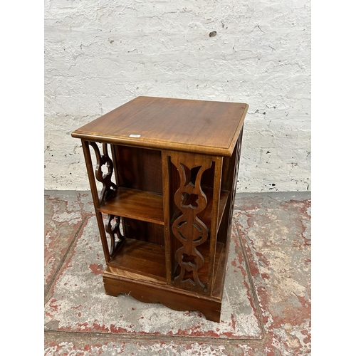 204 - An Edwardian style hardwood revolving bookcase with fretwork panels