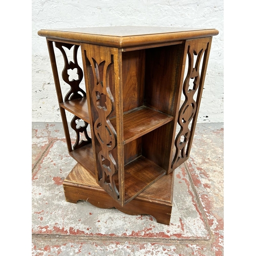 204 - An Edwardian style hardwood revolving bookcase with fretwork panels