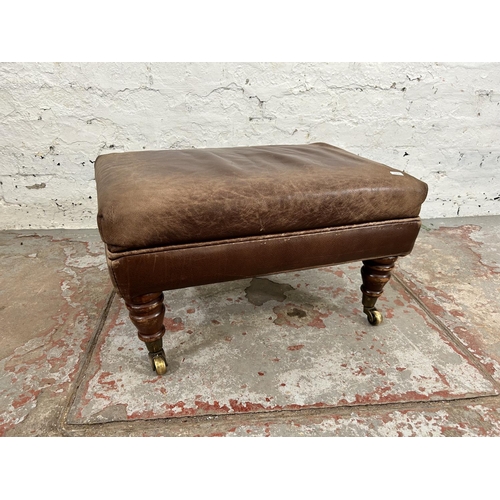 213 - A 19th century style brown leatherette footstool with mahogany supports and brass castors