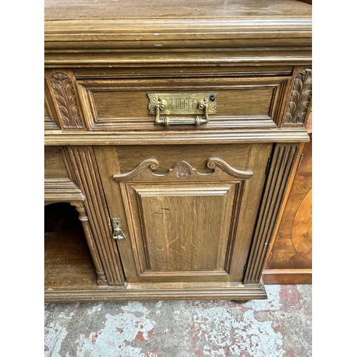 27 - A late 19th/early 20th century carved oak sideboard with galleried back, four drawers and two cupboa... 