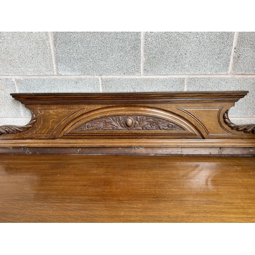 27 - A late 19th/early 20th century carved oak sideboard with galleried back, four drawers and two cupboa... 