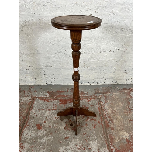 37 - A mid 20th century oak circular top jardinière stand - approx. 85cm high