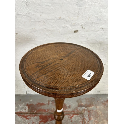 37 - A mid 20th century oak circular top jardinière stand - approx. 85cm high