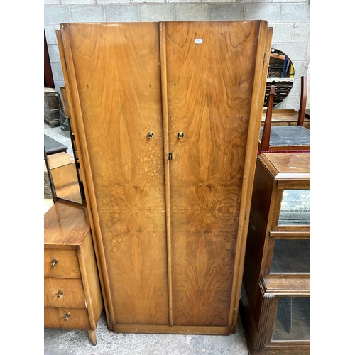 44 - A mid 20th century walnut two piece bedroom suite comprising double wardrobe and dressing table