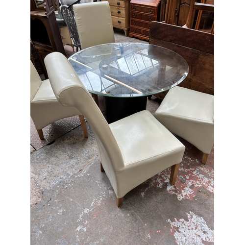 53 - A modern glass top circular dining table on brown leatherette pedestal base and four cream leatheret... 