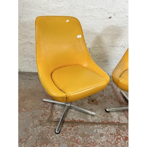 59 - A pair of mid 20th century yellow vinyl and chrome plated swivel dining chairs