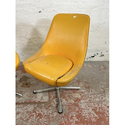 59 - A pair of mid 20th century yellow vinyl and chrome plated swivel dining chairs