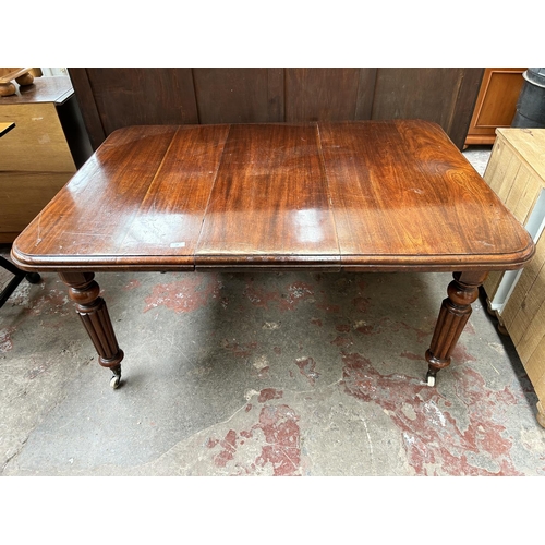 60 - A Victorian mahogany rectangular wind out extending dining table with reeded supports and winder - a... 