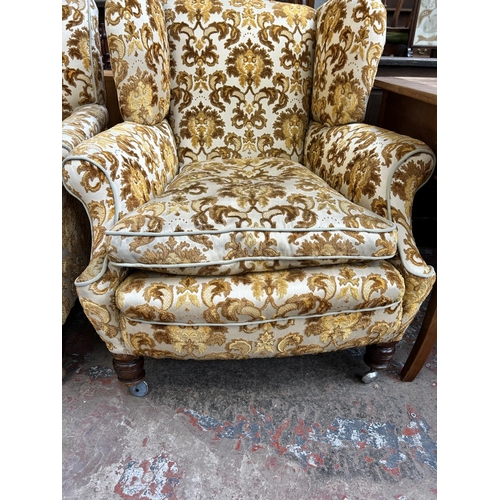 68 - A pair of early 20th century floral upholstered his and hers armchairs on mahogany turned supports a... 