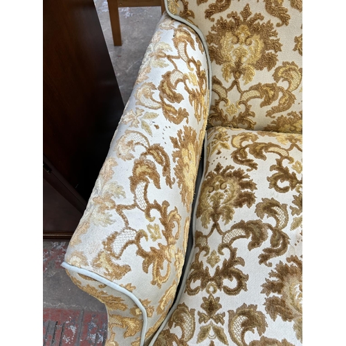 68 - A pair of early 20th century floral upholstered his and hers armchairs on mahogany turned supports a... 