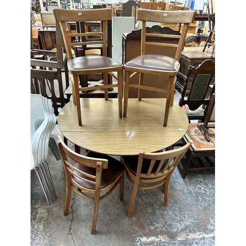 8 - A mid 20th century teak effect and beech drop leaf oval kitchen table and four beech and brown vinyl... 