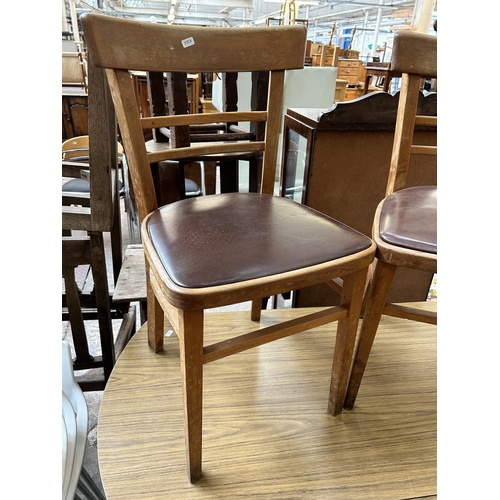 8 - A mid 20th century teak effect and beech drop leaf oval kitchen table and four beech and brown vinyl... 