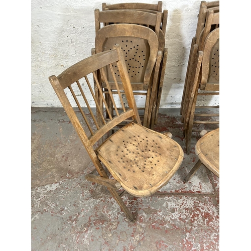 82 - Eight early 20th century beech folding church chairs