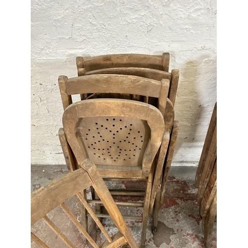 82 - Eight early 20th century beech folding church chairs