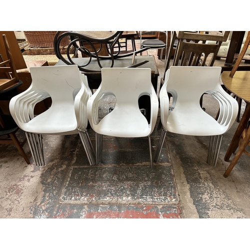 9 - Thirteen white plastic and tubular metal stacking armchairs