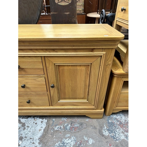 92 - A modern oak sideboard with three central drawers and two outer cupboard doors - approx. 86cm high x... 