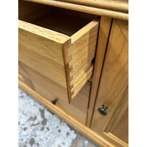 92 - A modern oak sideboard with three central drawers and two outer cupboard doors - approx. 86cm high x... 