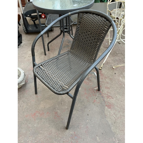 382A - A grey metal three piece patio set comprising circular table with tempered glass and two rattan effe... 