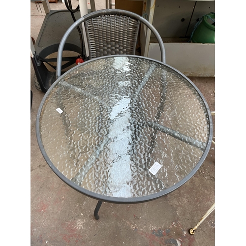 382A - A grey metal three piece patio set comprising circular table with tempered glass and two rattan effe... 