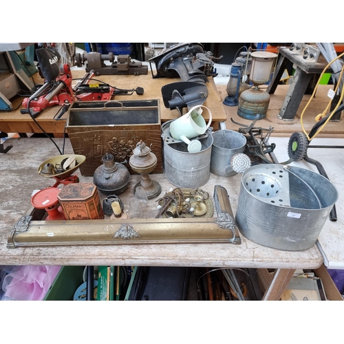 363 - A collection of metalware to include galvanised buckets, brass fire fender, copper oil lamp etc.