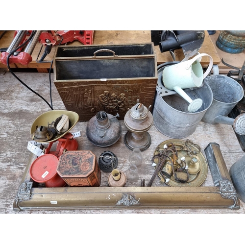 363 - A collection of metalware to include galvanised buckets, brass fire fender, copper oil lamp etc.