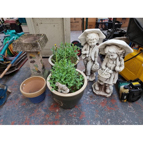 370 - Six garden items, two fibreglass boy and girl garden ornaments, three garden planters and one cast s... 