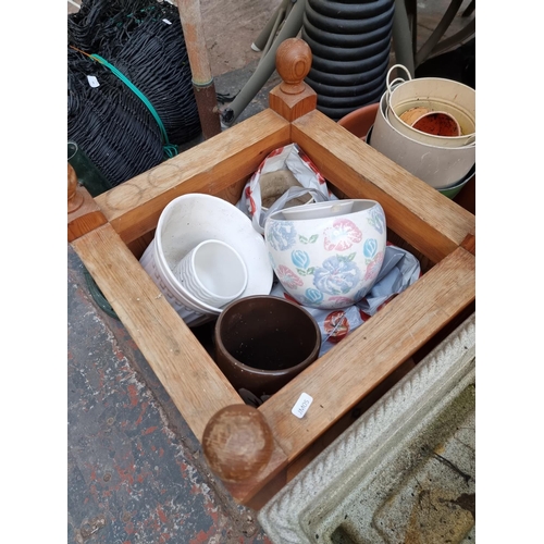 379 - A collection of garden items to include pine planter, cast iron parasol base, cast stone tree trunk ... 