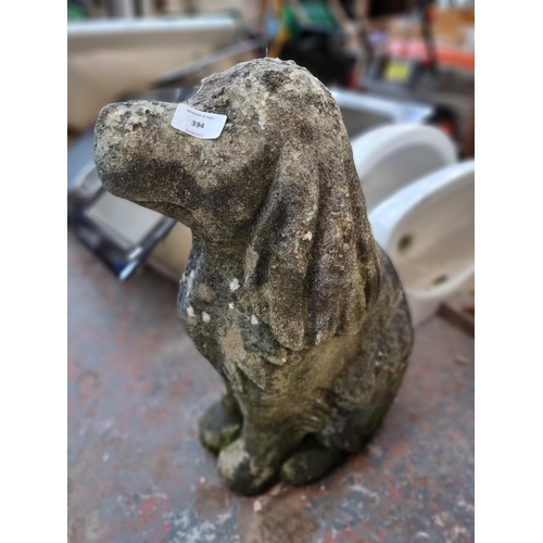 394 - A cast stone dog garden ornament - approx. 56cm high