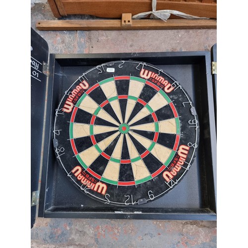 292 - A Winmau dartboard in wooden wall mountable case