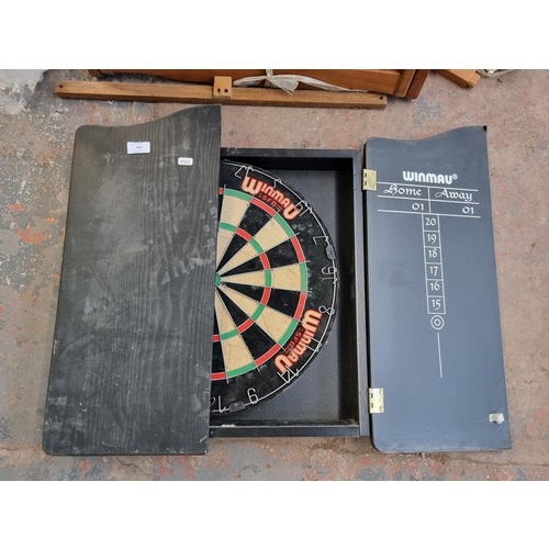 292 - A Winmau dartboard in wooden wall mountable case