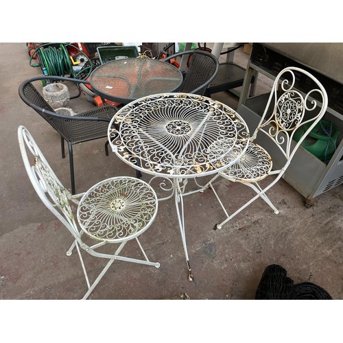 382 - A 19th century style filigree effect wrought iron three piece patio set comprising two folding chair... 