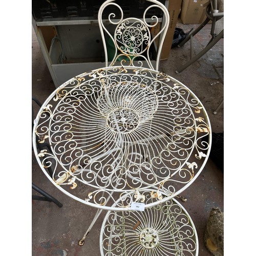 382 - A 19th century style filigree effect wrought iron three piece patio set comprising two folding chair... 