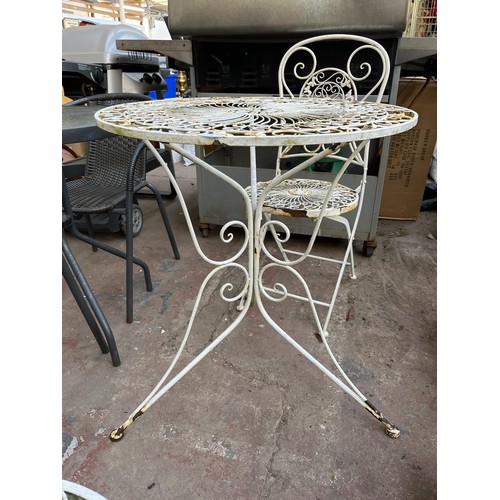 382 - A 19th century style filigree effect wrought iron three piece patio set comprising two folding chair... 