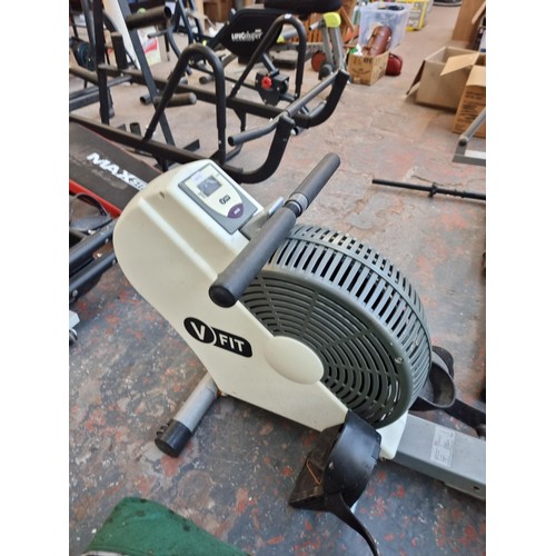 301 - A collection of exercise equipment to include V-Fit rowing machine, black metal barbell, Reebok cros... 