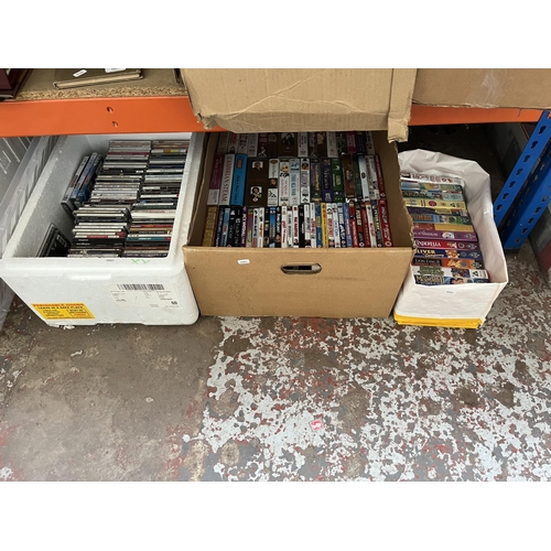 411 - Twelve boxes containing a large quantity of DVDs, CDs and VHS tapes