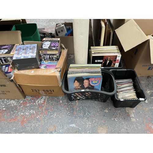 414 - Five boxes and two record cases containing a large quantity of VHS tapes, books and vinyl records