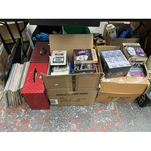 414 - Five boxes and two record cases containing a large quantity of VHS tapes, books and vinyl records