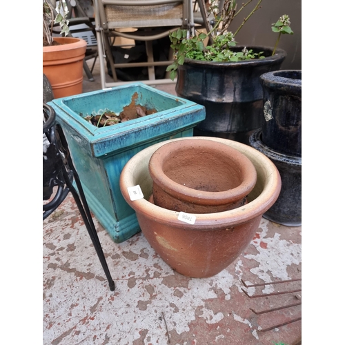 377 - Nine items, eight glazed and terracotta planters and one wrought iron plant stand