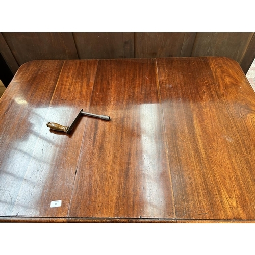 60 - A Victorian mahogany rectangular wind out extending dining table with reeded supports and winder - a... 